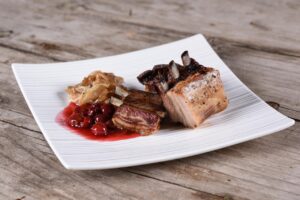 Wildschweinbraten auf Teller mit Preiselbeeren