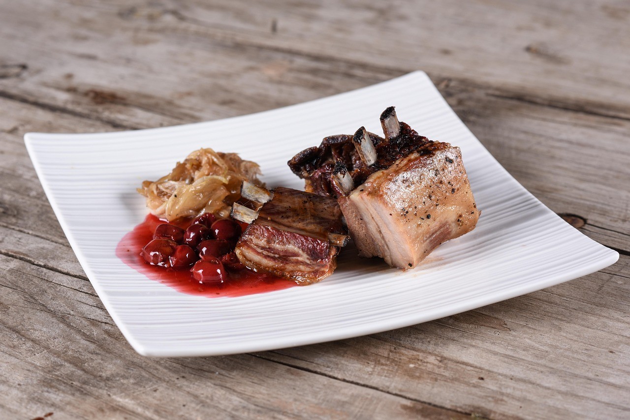 Nachhaltige Lebensmittel Wildschweinbraten auf Teller mit Preiselbeeren