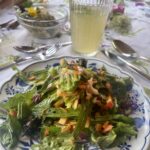 Teller mit Wildkräutersalat und ein Glas mit Holunderlimonade